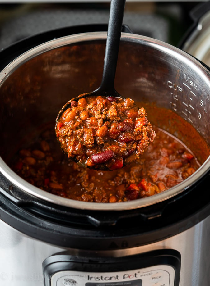 Scoop of chili with beans inside instant pot.