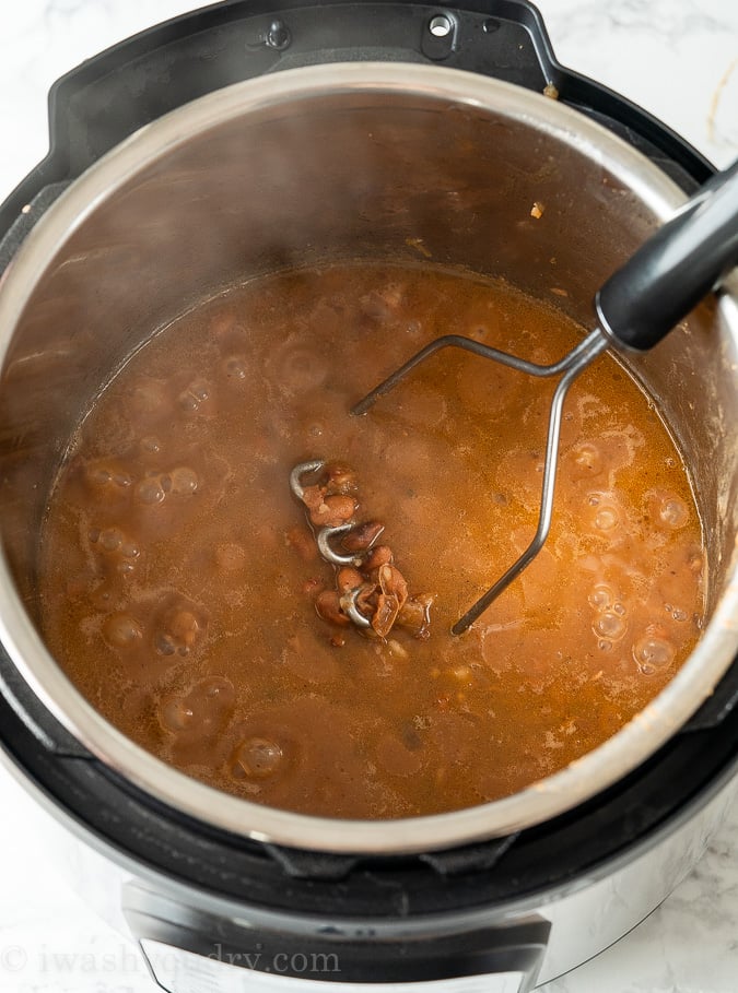 Mash the cooked beans with a potato masher to get the desired consistency of refried beans you would like.