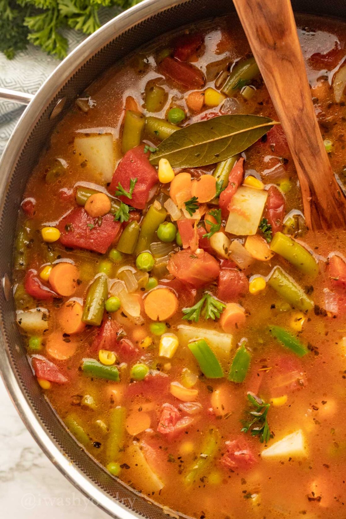 Pot of vegetable soup with plenty of carrots, potatoes and green beans.