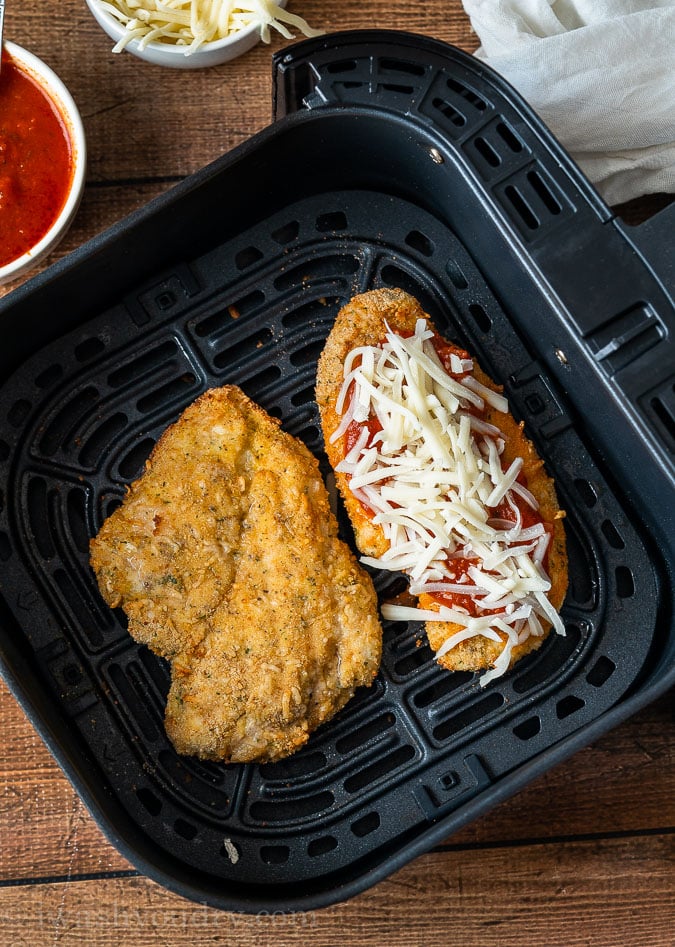 Crispy Chicken Parmesan in the air fryer with marinara sauce and cheese on top.