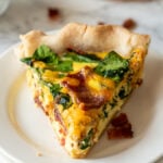 Bacon Cheddar Quiche Recipe : slice of quiche on white plate.