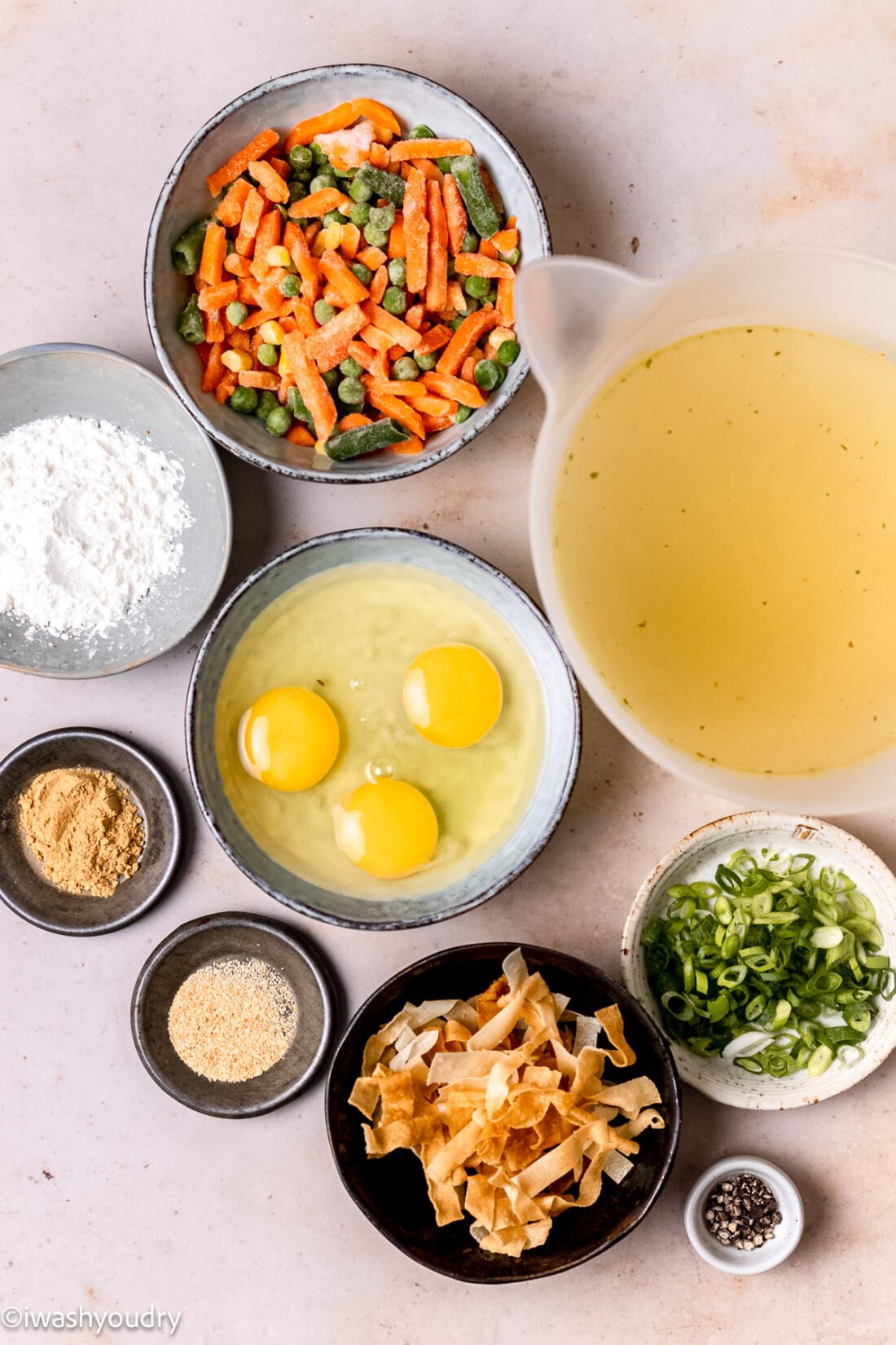 Raw ingredients for egg drop soup in glass bowls. 