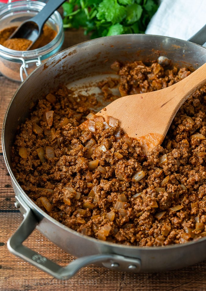 The BEST Homemade Taco Meat in a skillet with a wooden spoon