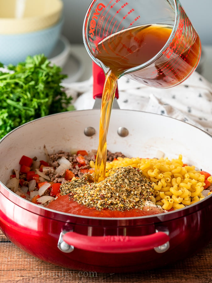 Pour beef broth into pot filled with ground beef, tomato sauce and macaroni noodles.