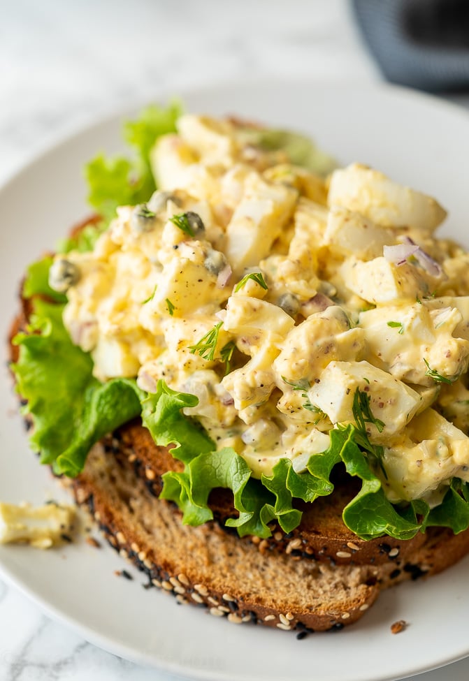 Lemon Caper Egg Salad Recipe on top of green lettuce and toasted bread.