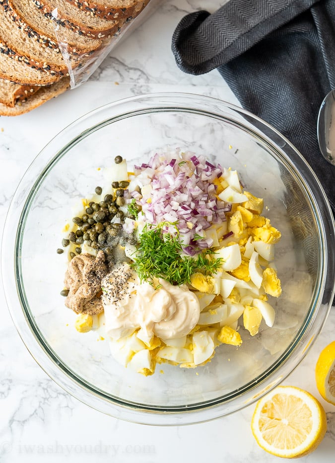 Ingredients for Egg Salad include hardboiled eggs, purple onion, fresh dill, mayo, dijon mustard, capers and lemon