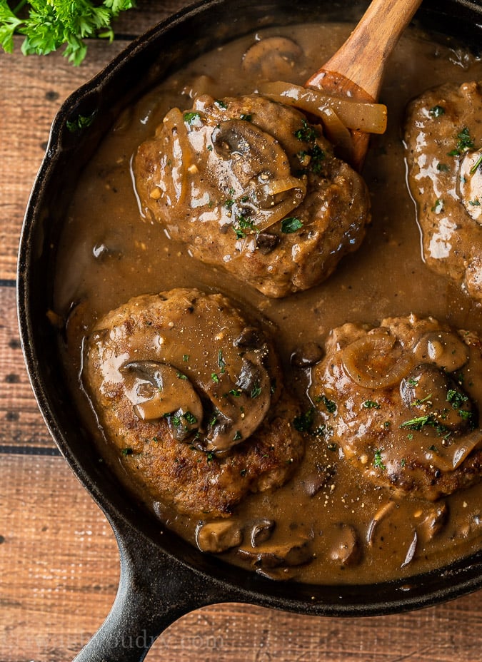 Quick Salisbury Steaks in a skillet with brown mushroom gravy sauce.