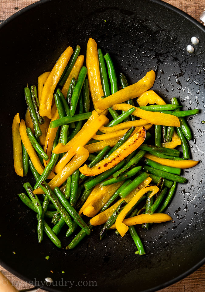 Sauté green beans and yellow peppers in a hot skillet until lightly charred.