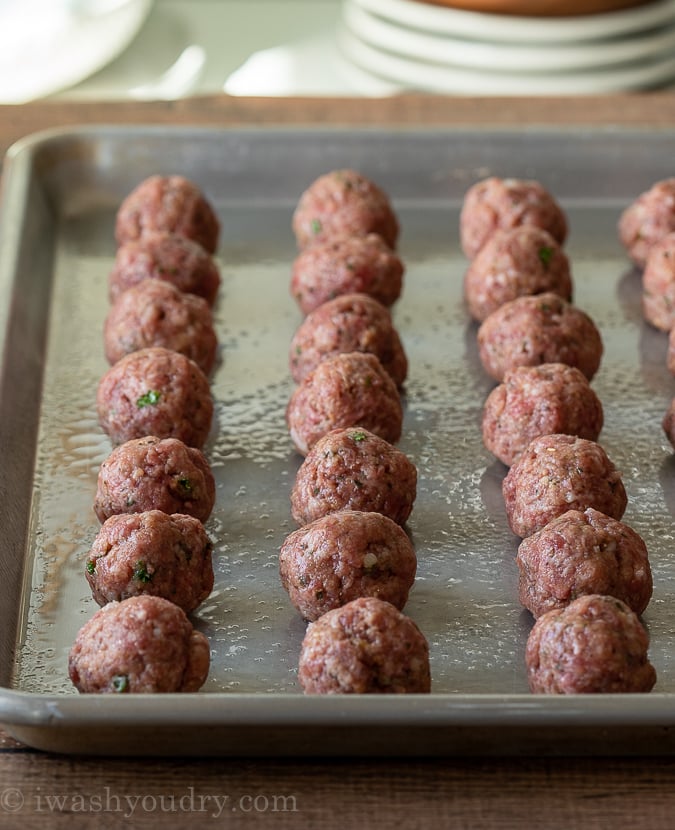 Meatballs unbaked on a tray ready for the oven