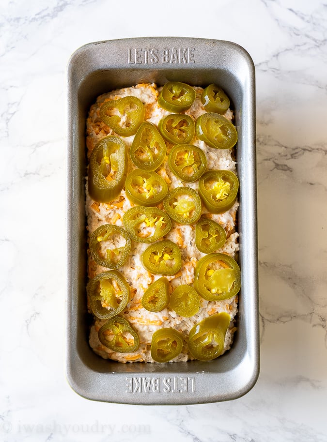 Layer pickled jalapeños all over the top of the bread before baking.