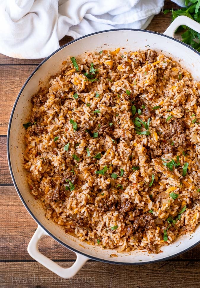 Cheesy Taco Rice in a large white skillet topped with cilantro.