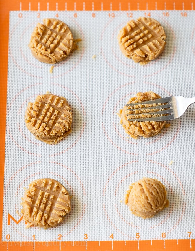 Use a fork to gently press down the peanut butter cookies and create lines on top before baking. 