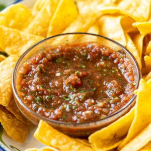 Bowl of restaurant style salsa with crispy tortilla chips surrounding it.