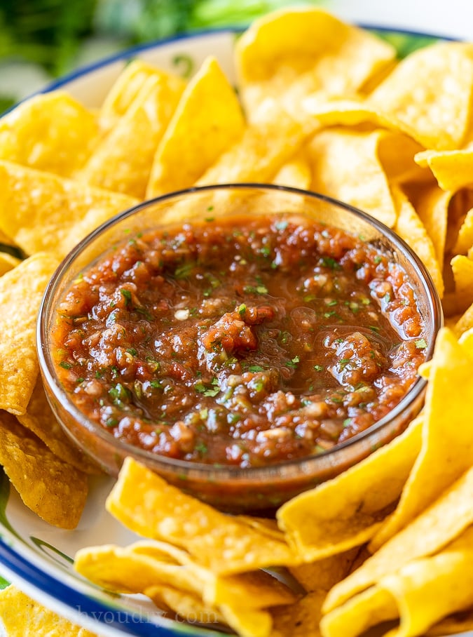 Bowl of restaurant style salsa with crispy tortilla chips surrounding it.