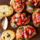 Slices of toasted baguette with fresh tomato bruschetta on top.
