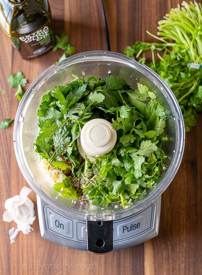 Chimichurri ingredients in a food processor ready to be blended.