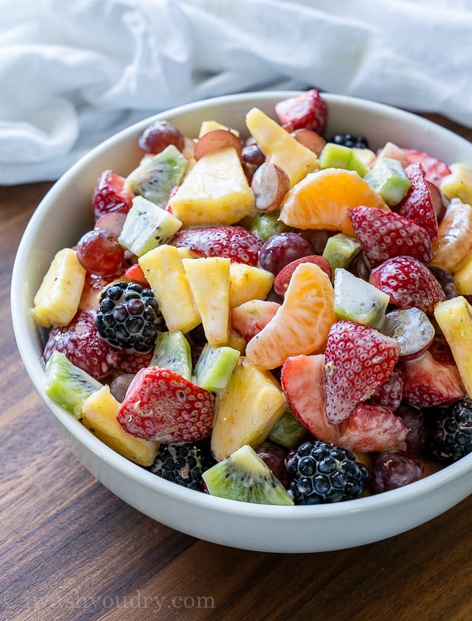 This Creamy Fresh Fruit Salad recipe is filled with loads of fresh fruit in a light Greek yogurt dressing and a hint of honey and lime! Perfect for potlucks and parties!