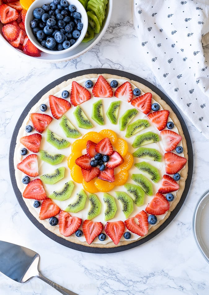 This quick and easy Fruit Pizza Recipe has a tender cookie base with a creamy cheese frosting and assorted fresh fruits on top.