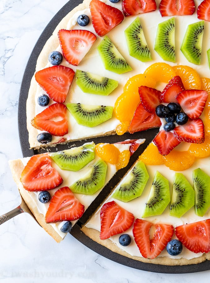 Sliced Fruit Pizza with cream cheese frosting and fresh fruits.