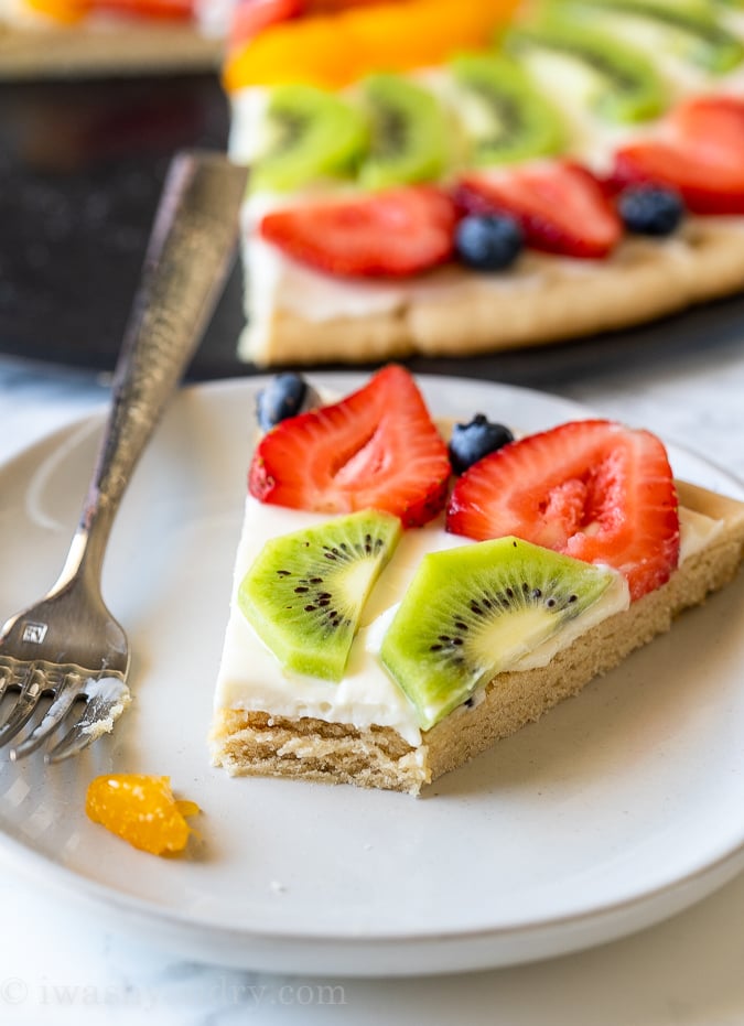 Soft sugar cookie fruit pizza with bite taken