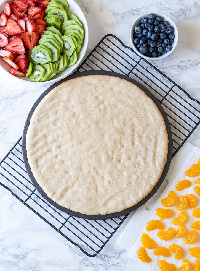 Pressed Sugar Cookie Crust in a pizza pan cooling on wire rack.