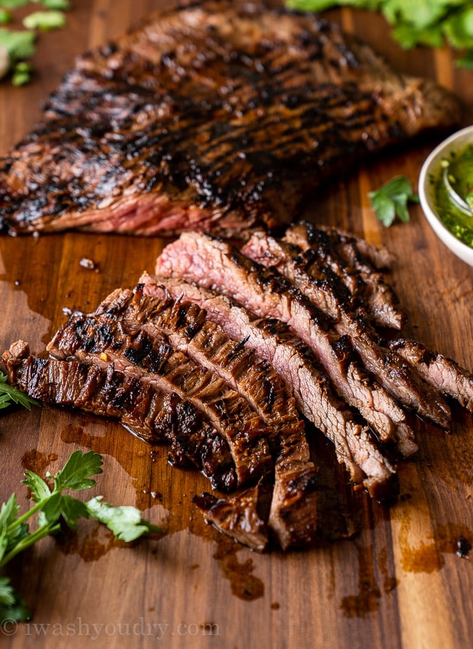 Thinly sliced skirt steak strips on a cutting board.