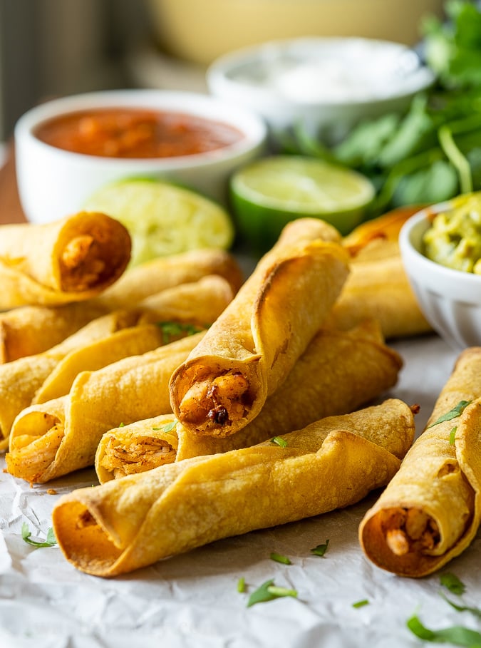 Plate full of crispy chicken taquitos