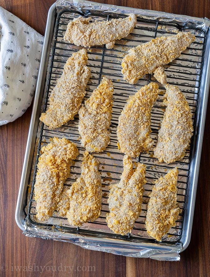 Arrange breaded chicken tenders on a baking sheet