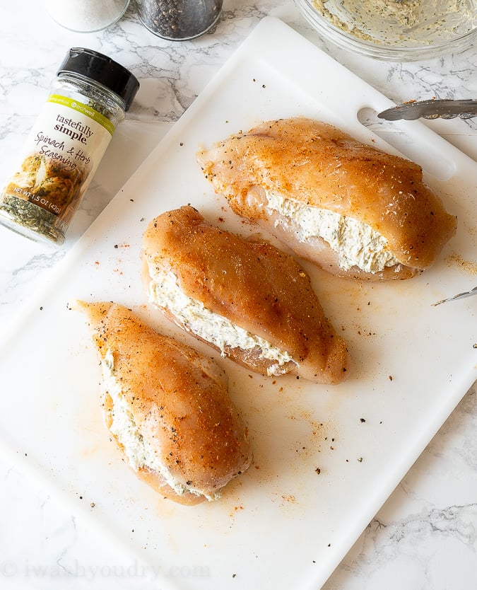 Stuffed chicken breast on a cutting board.