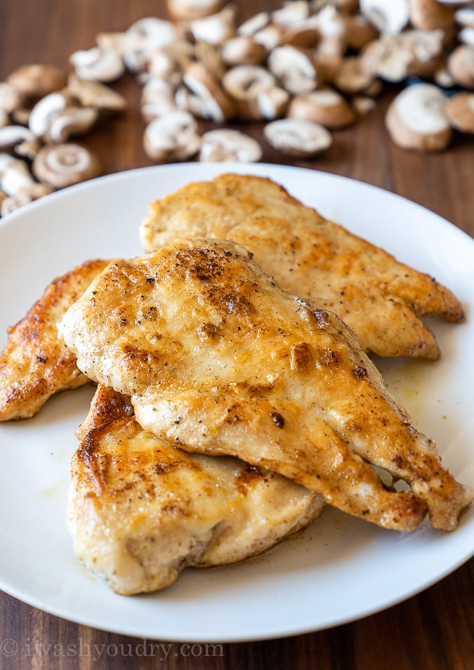 Pan seared chicken breast on a white plate.