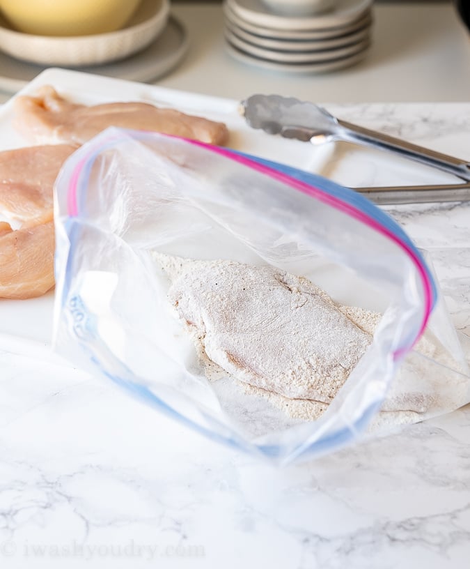 Dredge chicken breasts in flour before searing in skillet.