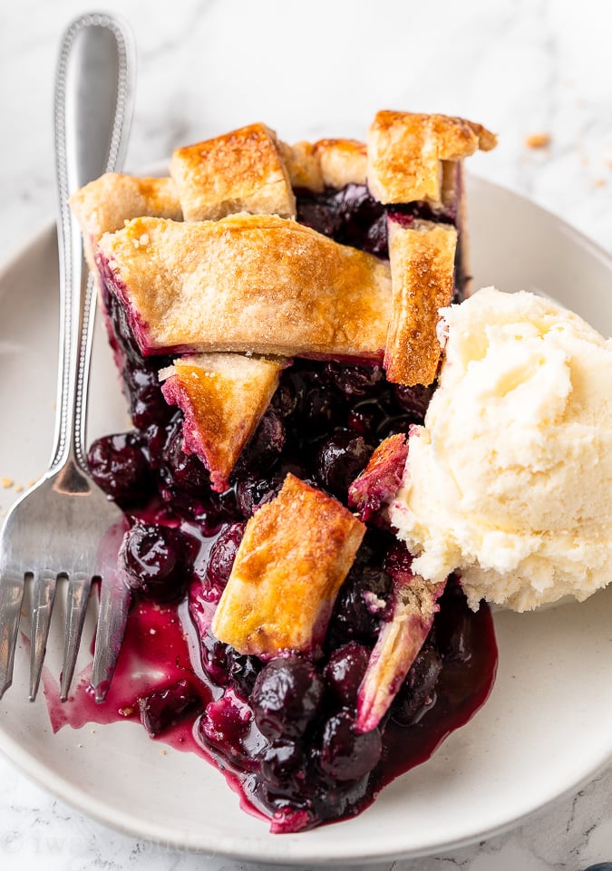 blueberry pie on plate with vanilla ice cream