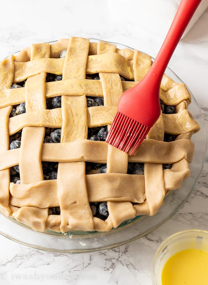 brushing pie dough with egg wash