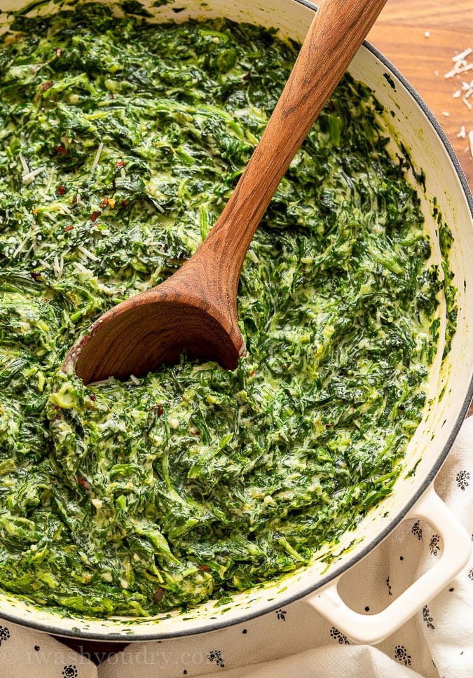 Pan of creamed spinach with wooden spoon