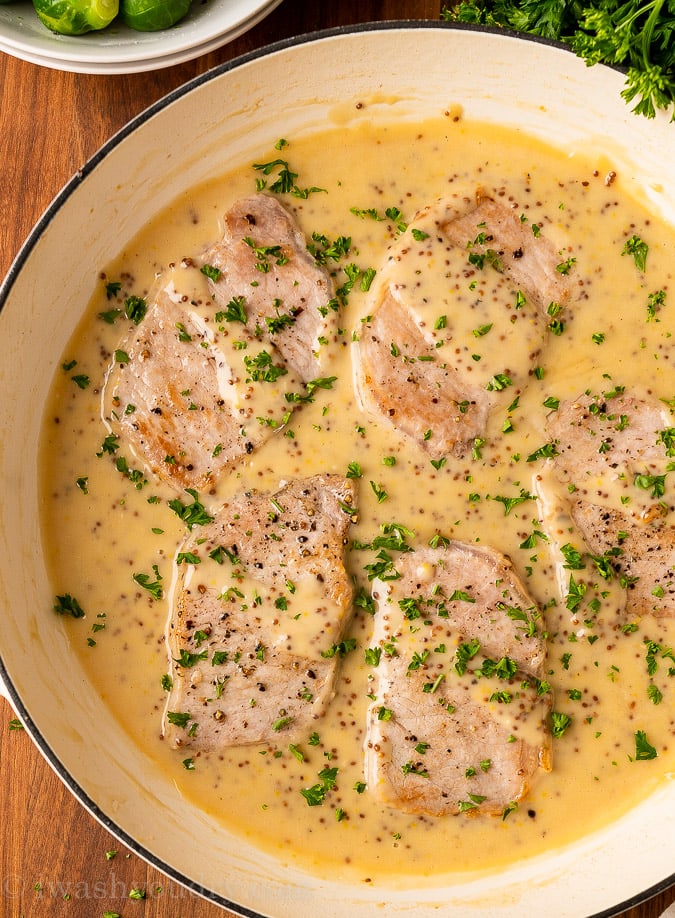 Pork chops in pan with mustard sauce
