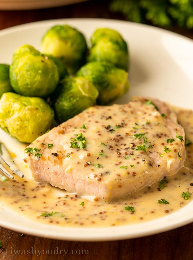 juicy pork chop on plate with mustard sauce