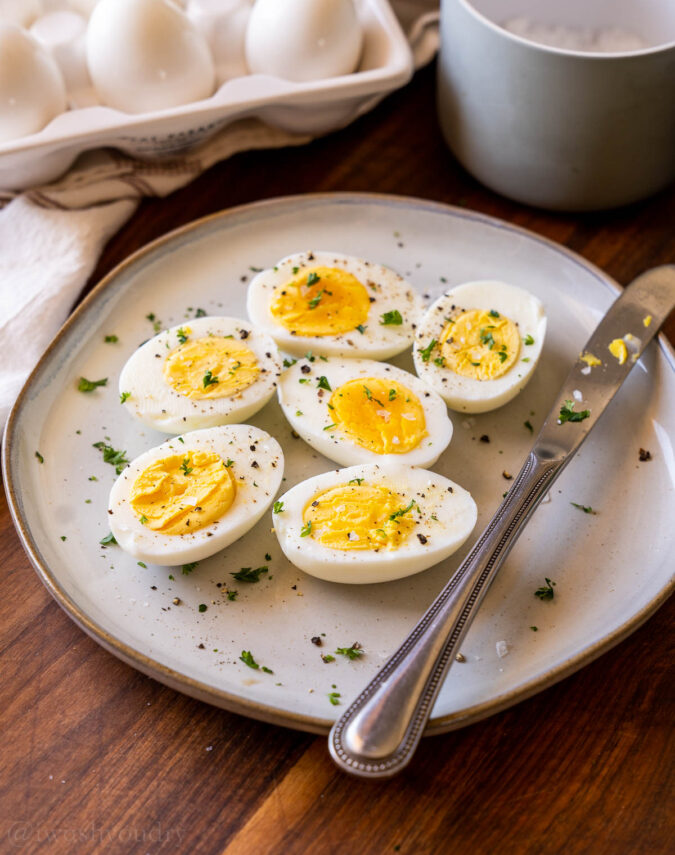 Hard boiled eggs on a plate with salt and pepper