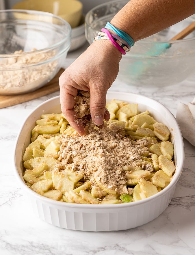 adding crumble topping to apple mixture