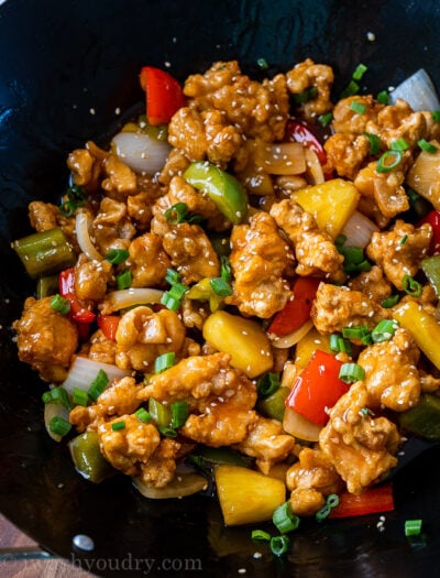 wok filled with sweet and sour chicken and vegetables