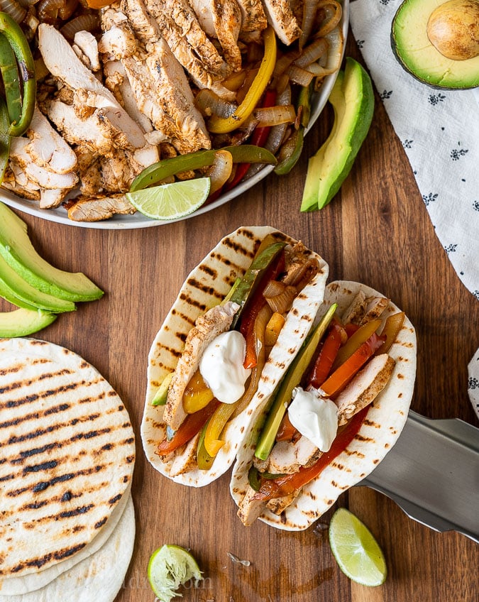 two chicken fajita tacos on wood surface