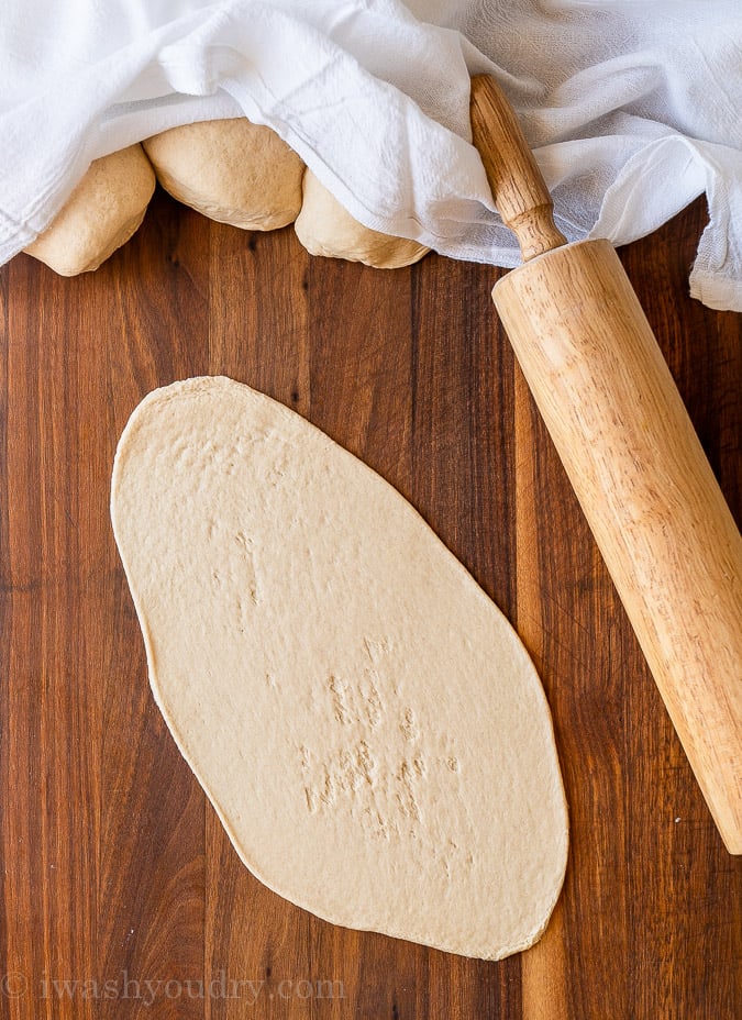 Rolled out naan bread on cutting board