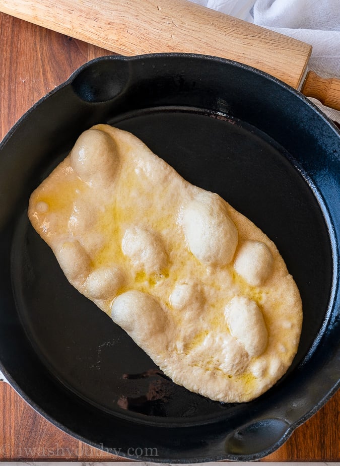 bubbles forming on naan bread in skillet