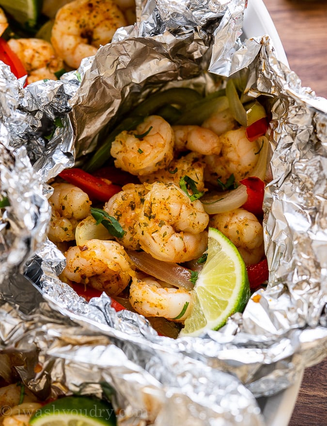 shrimp fajitas in foil packet with limes and peppers