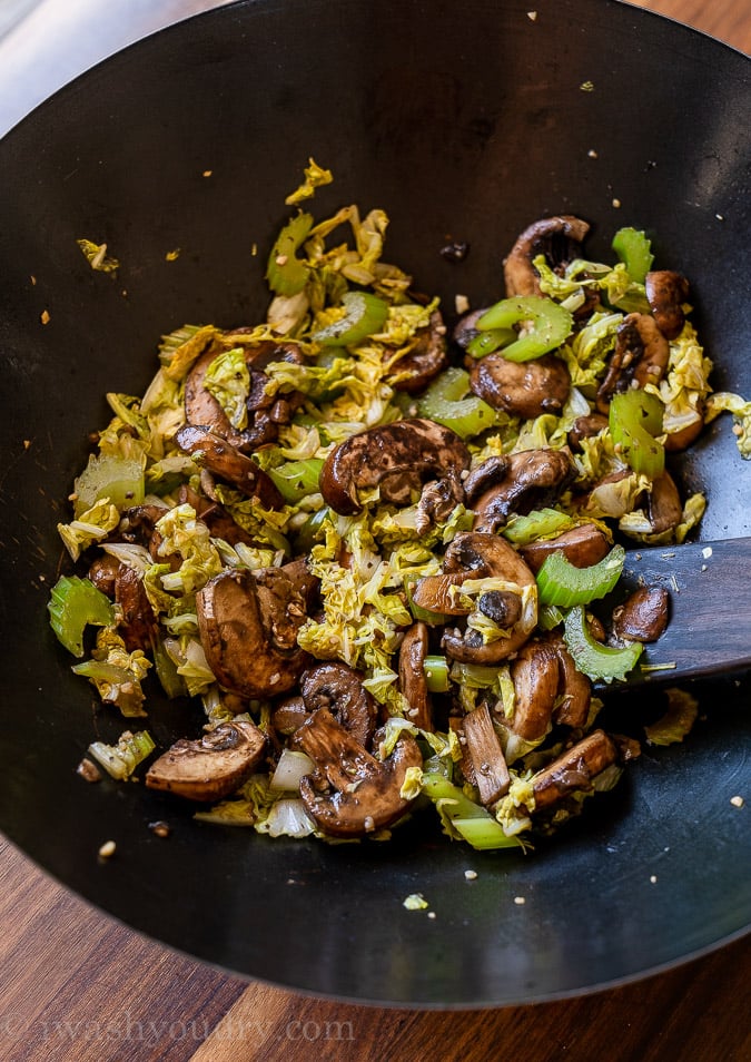 cooking vegetables in pan with mushrooms and cabbage