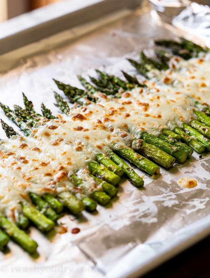 mozzarella cheese melted over asparagus in pan