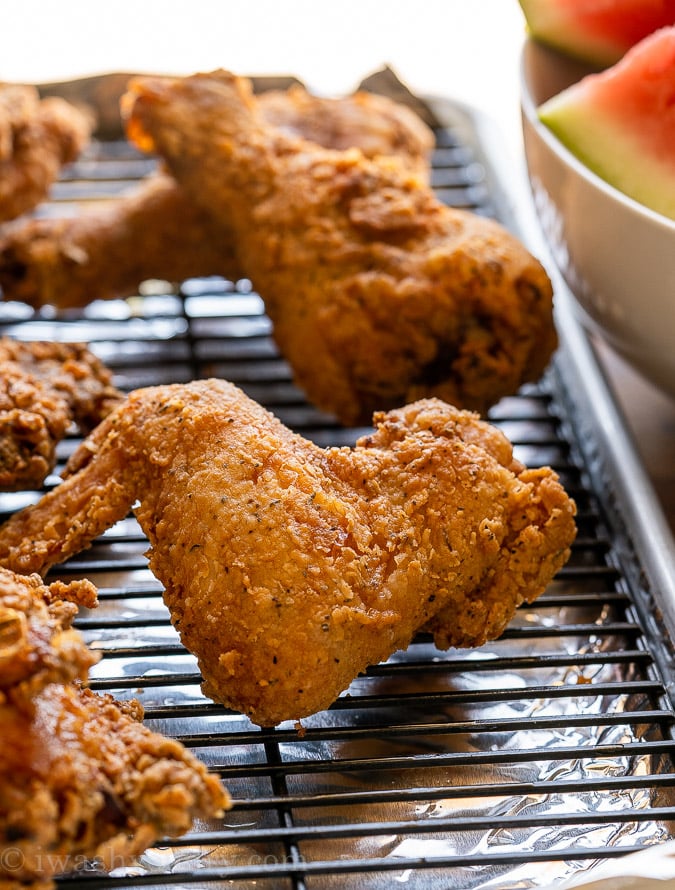 cooked chicken pieces on a wire rack in pan