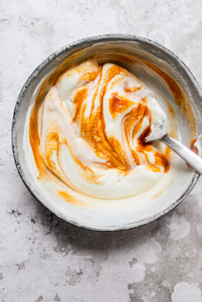 mixing sauce in a white bowl