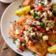 grilled salmon on white plate with greek salsa