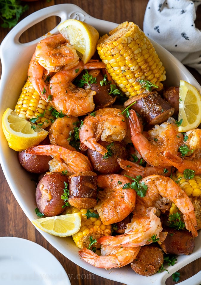 white dish filled with shrimp, potatoes, corn and sausage