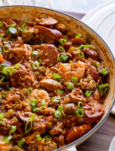 white pan filled with jambalaya with rice and green onions